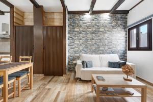 a living room with a couch and a stone wall at Villa Luisa en Frontera in Tigaday