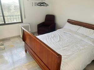 1 dormitorio con 1 cama, 1 silla y 1 ventana en Rustic mountain view apartment, en Cogollos De La Vega