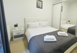 a bedroom with a bed with two towels on it at River Place Apartment - Iulius Mall in Iaşi