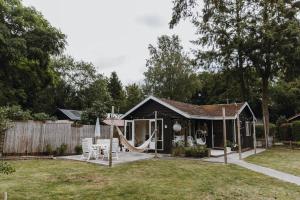 una pequeña casa con una hamaca en el patio en BOHO Holiday Home (bekend van VT Wonen), en Ermelo