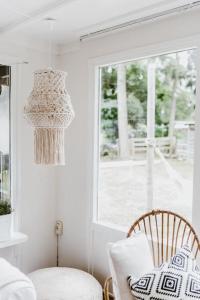 Habitación con lámpara de araña, silla y ventana en BOHO Holiday Home (bekend van VT Wonen), en Ermelo