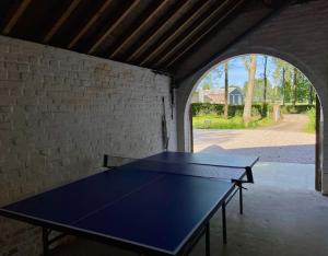 - une table de ping-pong dans une pièce dotée d'un mur en briques dans l'établissement Villa Marie-Lou entièrement rénovée, à Neuville-sous-Montreuil