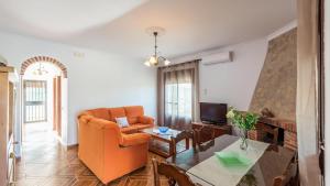salon z pomarańczowym krzesłem i stołem w obiekcie Fuente Barrera El Gastor by Ruralidays w mieście El Gastor