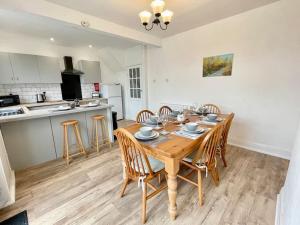 a kitchen and dining room with a wooden table and chairs at City Haven Luxurious 3-Bed Retreat in Portsmouth