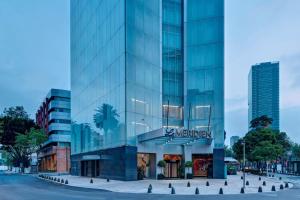 メキシコシティにあるエンバシー スイーツ ホテル バイ ヒルトン メヒコ シティ レフォルマの標識が書かれた高いガラス張り