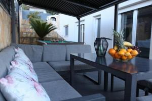 Luxury Villa Lana Apt, Seaview Terrace, Large Outdoor Space, BBQ في تروغير: غرفة معيشة بها أريكة وطاولة عليها فاكهة