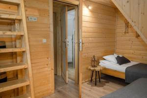 a small room with a bed in a wooden cabin at Zakopiańska Osada Apartamenty in Zakopane