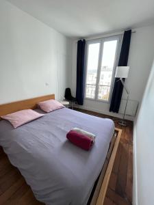 a bedroom with a large bed with pink pillows on it at Charming apartment in Montmartre in Paris