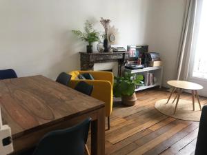 een woonkamer met een tafel en gele stoelen bij Charming apartment in Montmartre in Parijs