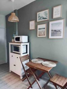 una cucina con forno a microonde, tavolo e sedie di Studio «  La Mouette Rieuse » a Le Touquet-Paris-Plage
