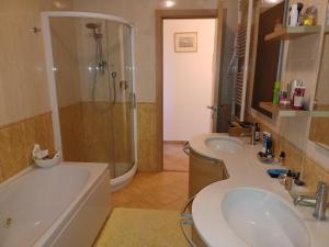 a bathroom with two sinks and a shower and a tub at CASAVACANZE MEVANIA in Bevagna