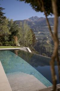 a swimming pool with a view of a mountain at Private Suites COLLIS - Feel good Resort Johannis in Tirolo