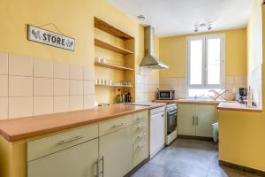 een keuken met gele muren en houten aanrechtbladen bij Maison du capitole in Narbonne