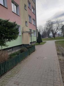 um passeio ao lado de um edifício ao lado de uma cerca em Family Suite Świecie em Swiecie