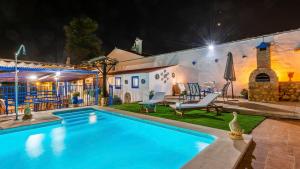 a swimming pool in front of a house at night at Cortijo Los Mellizos Penaflor by Ruralidays in Peñaflor