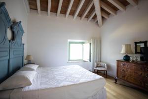 a bedroom with a bed and a dresser and a window at La Marcona in Serramazzoni