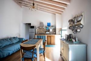 a kitchen and living room with a table and a blue couch at La Marcona in Serramazzoni