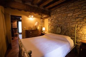 ein Schlafzimmer mit einem großen Bett in einer Steinmauer in der Unterkunft La Marcona in Serramazzoni
