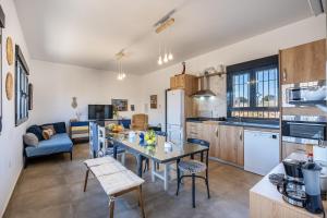 a kitchen and living room with a table and chairs at La Parva - Casa rural Eralta in Dúrcal +24 photos