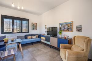 a living room with a blue couch and a tv at La Parva - Casa rural Eralta in Dúrcal