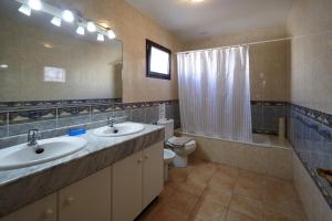 łazienka z dwiema umywalkami i toaletą oraz lustrem w obiekcie Casa Hawkeshead - LH108 By Villas Now Ltd w mieście Playa Blanca