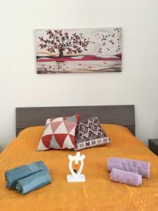 un letto con coperte e cuscini sopra di Casa Veronica a Tricase