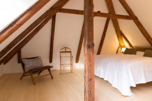 sypialnia na poddaszu z łóżkiem i krzesłem w obiekcie Apartement Schlaf Gut - mitten in der Wachau w mieście Weissenkirchen in der Wachau