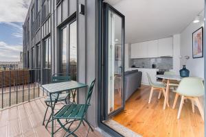 Apartamento con balcón con mesa y sillas. en Sunshine Luxury House Urban Retreat Downtown Porto, en Oporto