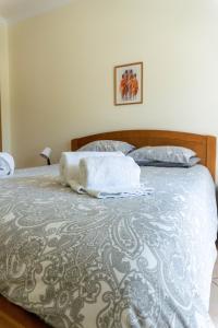 een bed met twee handdoeken bovenop bij Apartamento Karibu in Carvoeiro