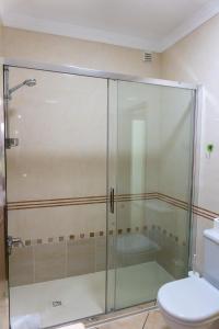 a glass shower in a bathroom with a toilet at Apartamento Karibu in Carvoeiro