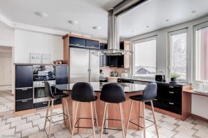 a kitchen with black cabinets and a table with chairs at Grand Villa Kivistö near Helsinki airport in Vantaa