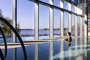 a woman sitting in a swimming pool with a view of the water at Gästehaus Landglück in Langen