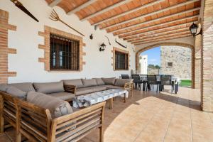 eine Terrasse mit einem Sofa, einem Tisch und Stühlen in der Unterkunft Mas del Vedell in L'Ampolla