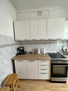 a kitchen with white cabinets and a stove top oven at Al-Dom Apartamenty Dworcowa 9 in Kołobrzeg
