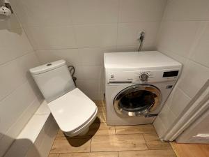 a small bathroom with a toilet and a washing machine at Al-Dom Apartamenty Dworcowa 9 in Kołobrzeg