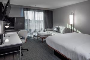 a hotel room with a bed and a couch at Courtyard by Marriott Conway in Conway