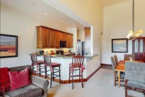 a kitchen and dining room with a bar with chairs at Snowmass Village, 3 Bedroom at Chamonix Ski-in Ski-out in Snowmass Village