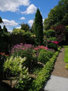 einen Garten mit bunten Blumen und einem Weg in der Unterkunft ElHa's FeWo in Gladbeck