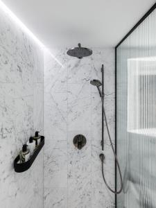 a bathroom with a shower with a glass wall at The Amauris Vienna - Relais & Châteaux in Vienna