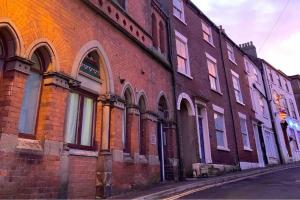 a red brick building on a city street at Church House Loft in Scarborough