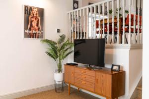 a living room with a television on a wooden dresser at Church House Loft in Scarborough