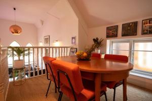 a dining room with a wooden table and orange chairs at Church House Loft in Scarborough