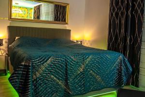 luxury Love Room Spa Whirlpool Jacuzzi في نورنبرغ: سرير مع لحاف أزرق في غرفة النوم