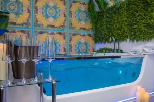 luxury Love Room Spa Whirlpool Jacuzzi في نورنبرغ: حمام به كاسات على طاولة بجوار حوض الاستحمام