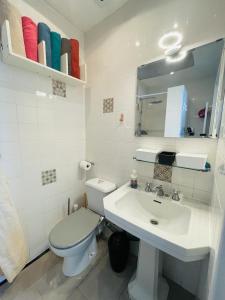 La salle de bains blanche est pourvue de toilettes et d'un lavabo. dans l'établissement New flat near Paris-Stade de France, à Aubervilliers