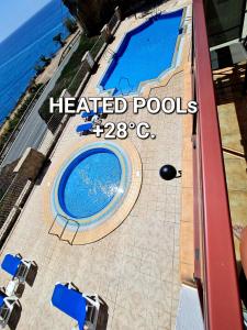 a swimming pool on a patio next to the ocean at DELUXE 3 Rooms74m2,TRANSFE-R inc! SEAVIEW on AMADORES,2 heatPOOLs, PARKING, 600 MB,Dishwasher,2Lift,,3 BEACHes in Playa del Cura