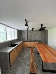 een keuken met een houten tafel en een wastafel bij Seiba Lodge 