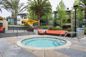 una piscina in un cortile con divano e alberi di Sunnyvale 1BR w WD Pool Gym near Googleplex SFO-1112 a Sunnyvale