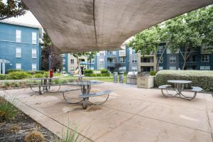 two tables and benches in a courtyard with buildings at Sunnyvale 1BR w WD Pool Gym near Googleplex SFO-1112 in Sunnyvale