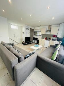 uma sala de estar com um sofá e uma cozinha em New flat near Paris-Stade de France em Aubervilliers